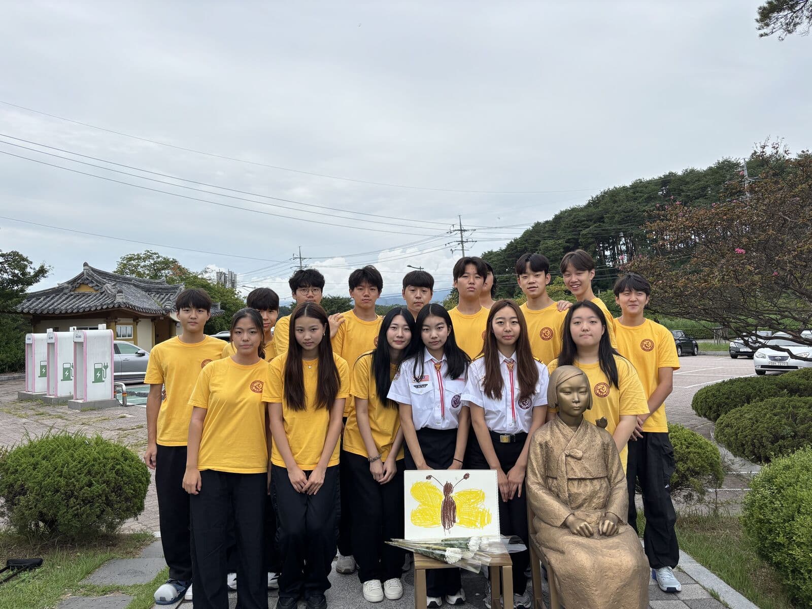 Hwarang members gathered at a Statue of Peace memorial